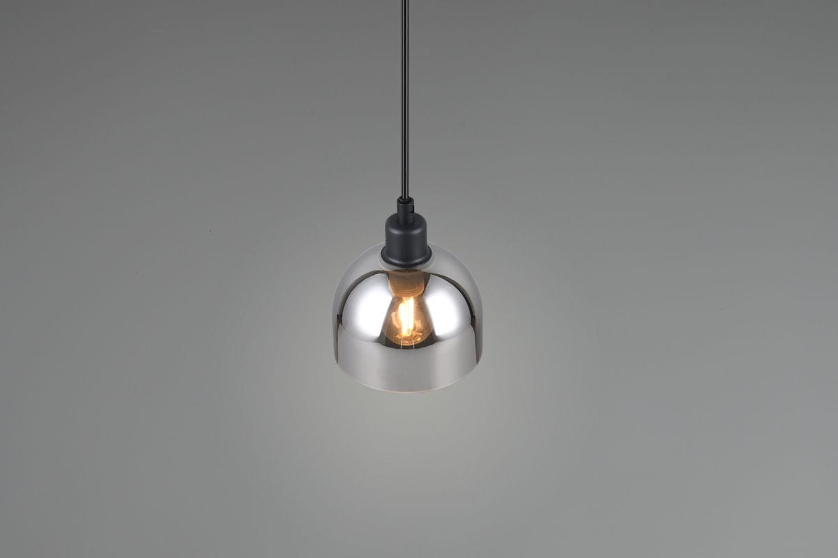 Lampa wisząca Molly z oprawą w kolorze czarnym i chromowanym, z kloszem w kształcie półkuli. Zawieszona na czarnym przewodzie, z widoczną żarówką E14. Tło w odcieniu szarym, neutralnym.