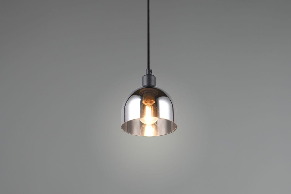 Lampa wisząca Molly z kloszem w kolorze chromu i czarnym wykończeniem, montowana na cienkim przewodzie. Kształt cylindryczny, z widoczną żarówką E14 wewnątrz. Tło proste, szare, podkreślające design lampy.