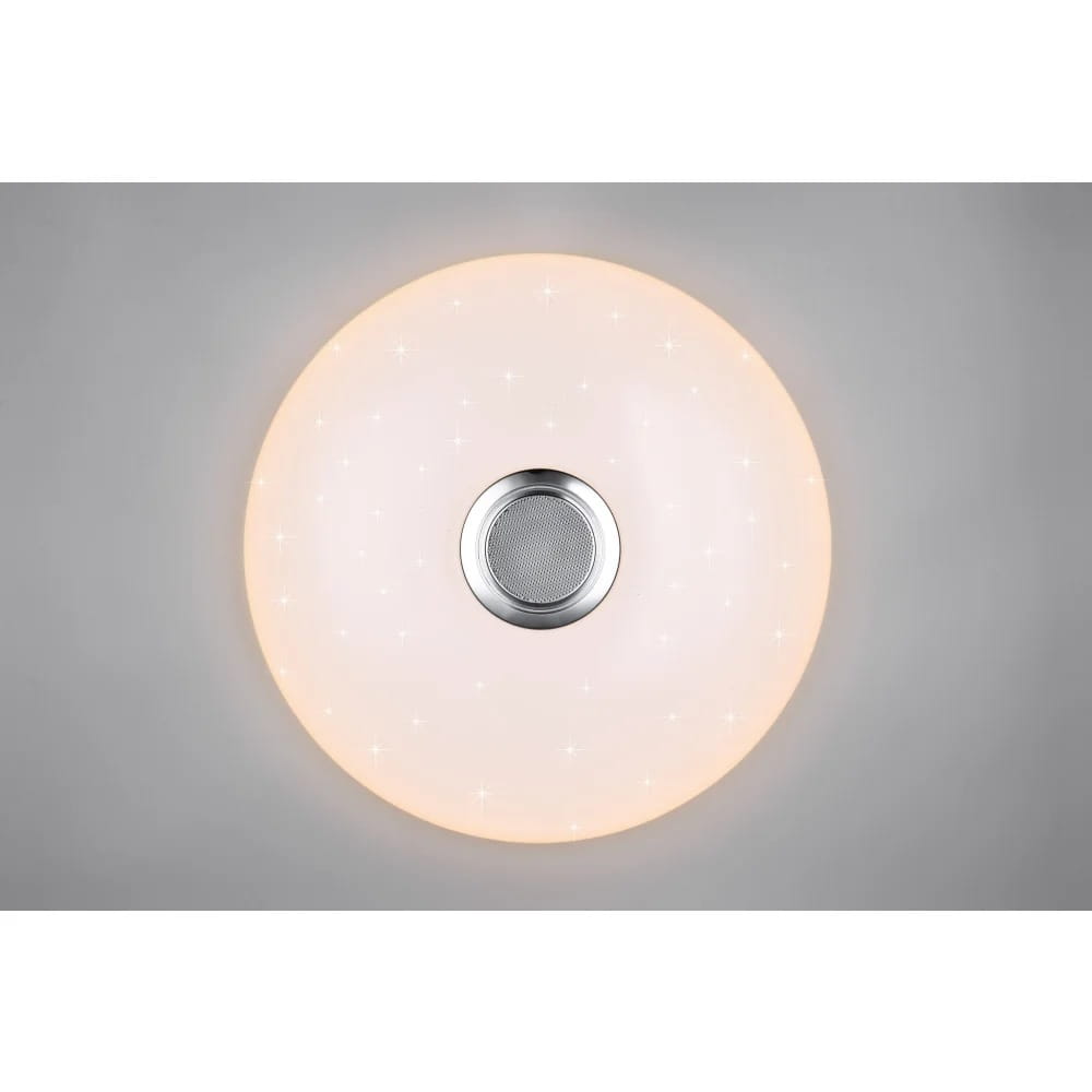 Plafon Musica w kolorze białym, okrągły, z pilotem, z jedną diodą LED (33W) RGBW. Centralnie umieszczona metalowa osłona z siateczką. Delikatne, błyszczące detale na powierzchni. Montowany sufitowo, widok z góry.