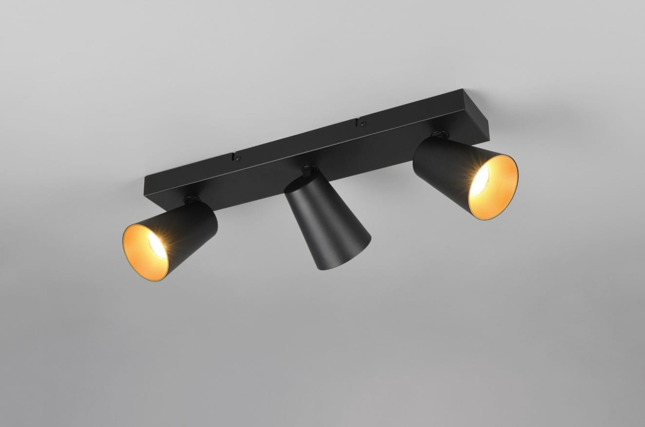 Lampa sufitowa Sharp z trzema reflektorami GU10 w kolorze czarnym. Reflektory mają cylindryczny kształt, skierowane są w dół, a ich wnętrza są w złotym kolorze. Produkt zamontowany jest na prostokątnej podstawie w kolorze czarnym.