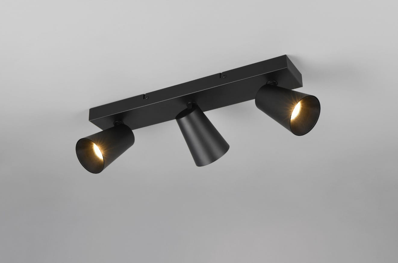 Czarna lampa sufitowa Sharp z trzema spotami GU10, zamontowana na prostokątnej podstawie. Każdy spot ma stożkowy kształt, emitujący ciepłe światło. Ujęcie z dołu, pokazujące detal konstrukcji i rozmieszczenie źródeł światła.