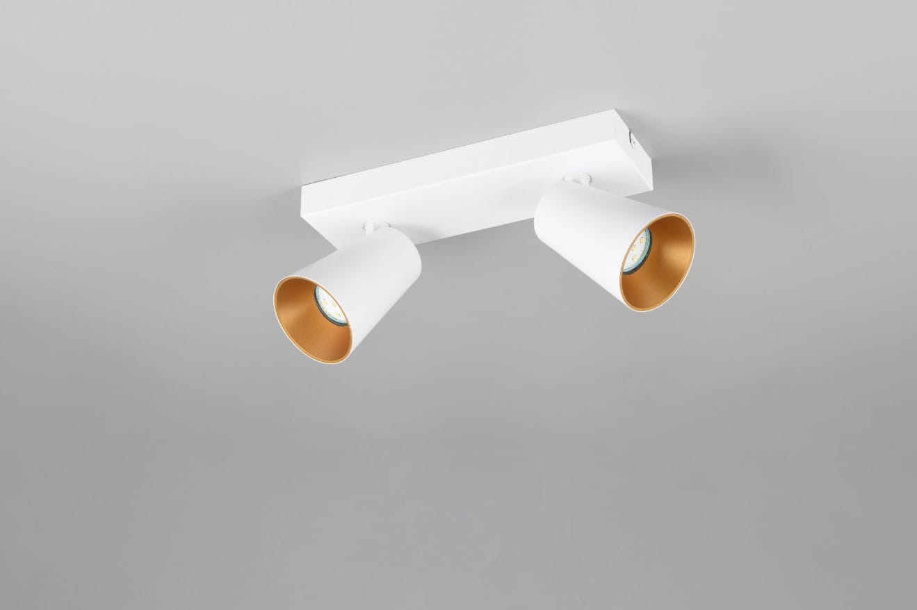 Biała lampa sufitowa typu spot z dwoma źródłami światła GU10. Okrągłe klosze zewnętrznie białe, wewnętrznie złote, zamontowane na prostokątnej podstawie. Ujęcie z góry, ukazujące detal konstrukcji i kolorystykę.