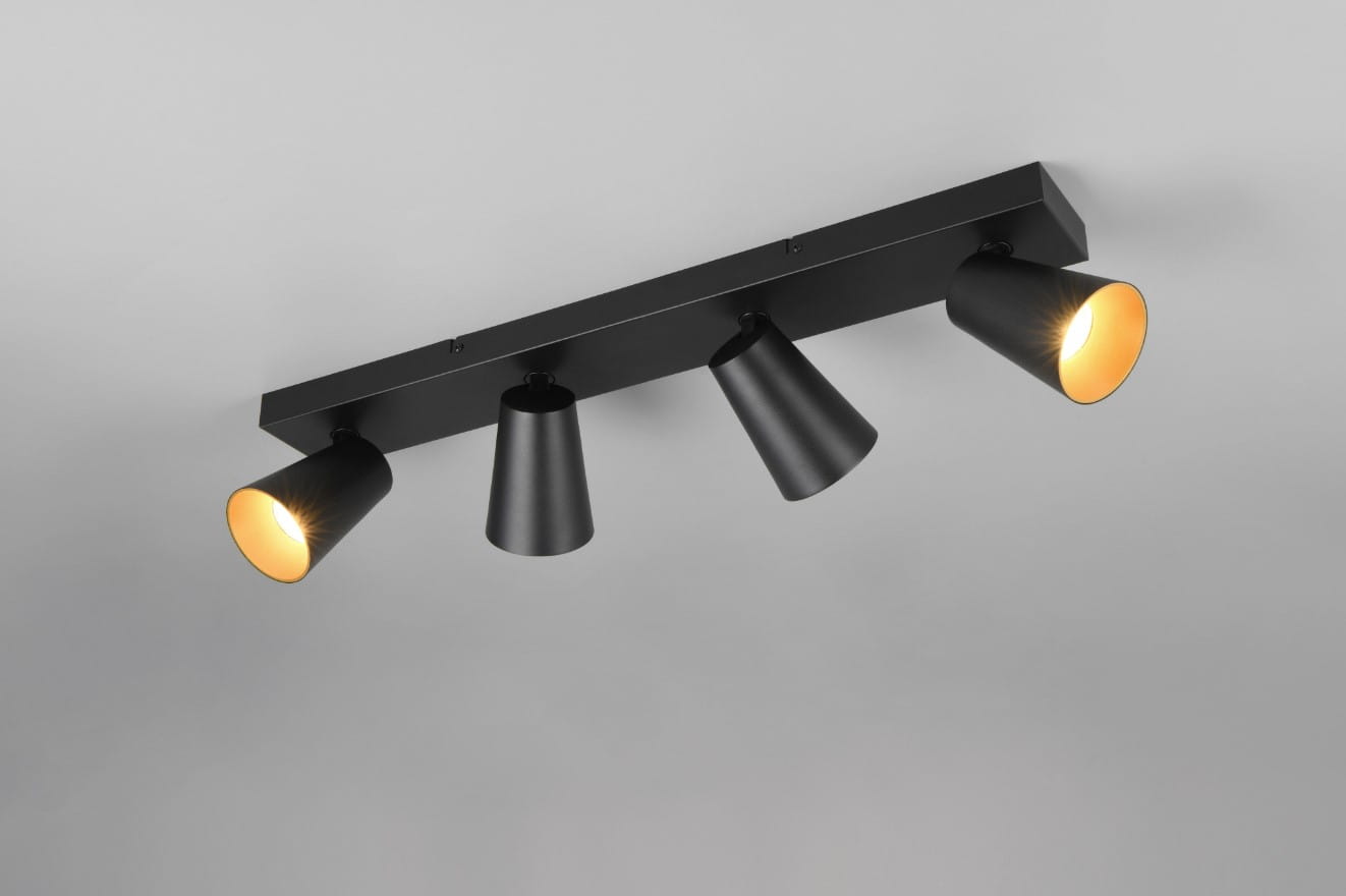 Czarna lampa sufitowa Sharp z czterema spotami GU10, zamontowana na prostokątnej podstawie. Reflektory o stożkowym kształcie, skierowane w różnych kierunkach, z widoczną ciepłą poświatą. Ujęcie z boku, na jednolitym tle.