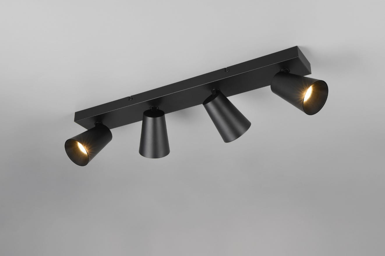 Czarna lampa sufitowa typu spot z czterema reflektorami GU10. Ujęcie z góry, montowana na suficie, z widocznymi kloszami w kształcie stożków. Dwa klosze świecą, a pozostałe dwa są wyłączone. Prosta konstrukcja na prostokątnej podstawie.