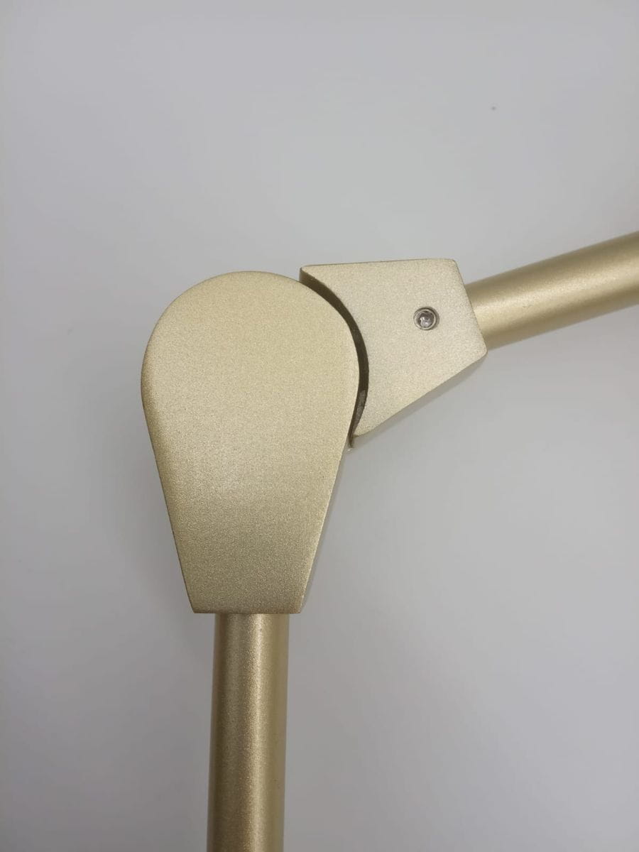 Zbliżenie na złoty element lampy wiszącej Modern Orchid, ukazujące ruchome połączenie z wykończeniem matowym. Widoczna konstrukcja z metalu, z delikatnie zaokrąglonymi krawędziami, na jednolitym tle.