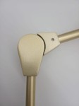 Zbliżenie na złoty element lampy wiszącej Modern Orchid, ukazujące ruchome połączenie z wykończeniem matowym. Widoczna konstrukcja z metalu, z delikatnie zaokrąglonymi krawędziami, na jednolitym tle.