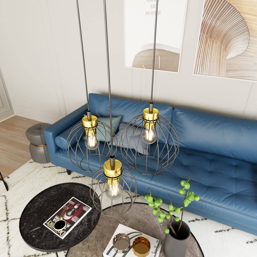 Lampa wisząca Nando 3GL z trzema oprawami E27 w kolorze czarno-złotym. Kule z metalowej siatki zawieszone na długich linkach, umieszczone nad niebieską sofą w nowoczesnym wnętrzu. Widoczne również okrągły stół i dekoracje.