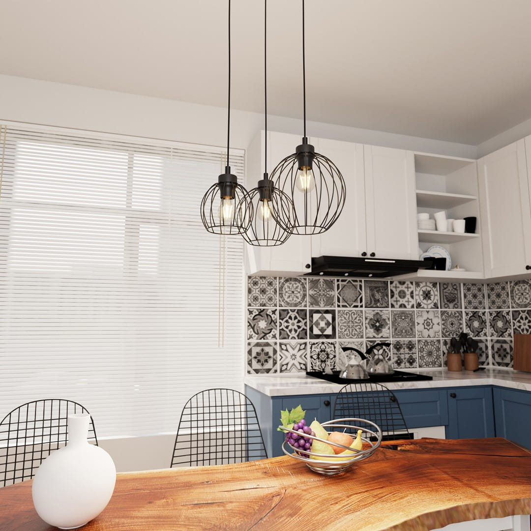 Lampa wisząca Nando 3BL w kolorze czarnym z trzema kloszami w formie siatki, zawieszona nad drewnianym stołem w nowoczesnej kuchni. W tle widoczne białe szafki oraz dekoracyjna płytka. W lampie zastosowano żarówki E27.