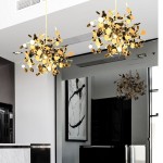 Lampa wisząca Monetti 3xG9 w kolorze złotym, z dekoracyjnymi elementami w kształcie liści, zawieszona w nowoczesnym wnętrzu. Widoczna w odbiciu w lustrze, umieszczona nad blatem. Kształt kulisty, z elementami metalowymi i białymi akcentami.