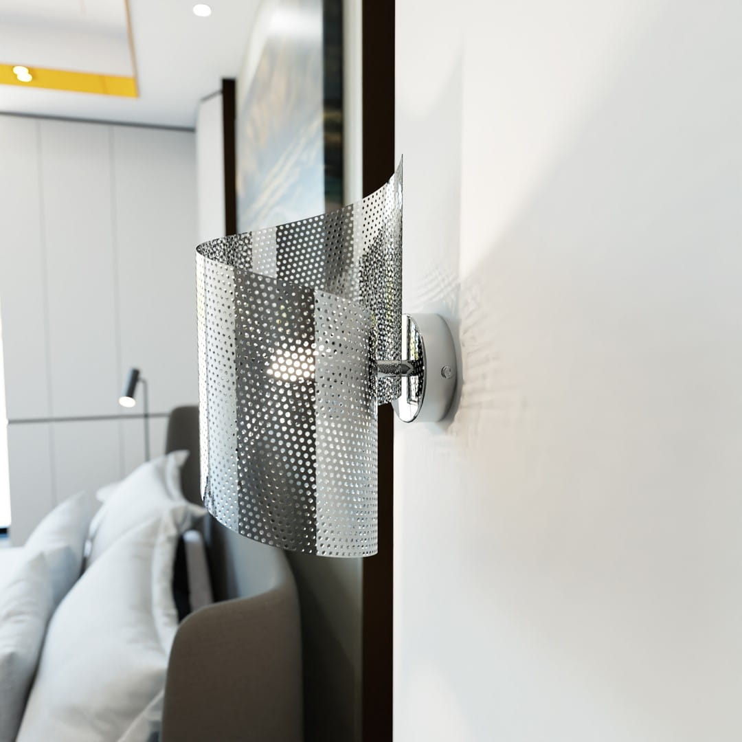 Kinkiet Spiral chrom 1xG9 w kolorze srebrnym, z unikalnym, perforowanym kloszem, zamontowany na ścianie. Produkt ma nowoczesny design i jest w pozycji pionowej, idealny do oświetlenia wnętrz. Tło stanowi jasna ściana.