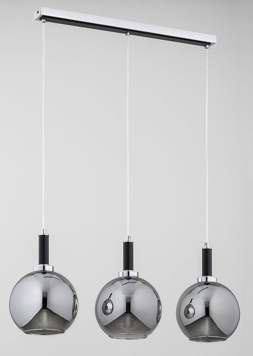 Lampa wisząca Hetty z trzema kulistymi kloszami w odcieniu chromu, zawieszona na białym, prostokątnym stelażu. Każdy klosz ma czarny uchwyt i jest wykonany z gładkiego, błyszczącego materiału. Długość linki do każdego klosza jest regulowana.
