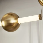 Lampa wisząca O-line S-4 w kolorze mosiądzu z czterema źródłami LED. Widoczna okrągła kula oraz prostokątny element świetlny. W komplecie z mocowaniem. Tło neutralne.