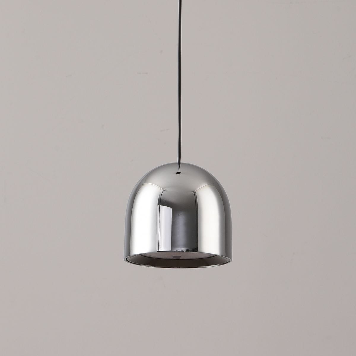 Lampa wisząca z chromowanym kloszem w kształcie półkuli, zawieszona na cienkim przewodzie. Wyposażona w jedno źródło światła LED o mocy 6W. Tło w jednolitym, neutralnym kolorze.