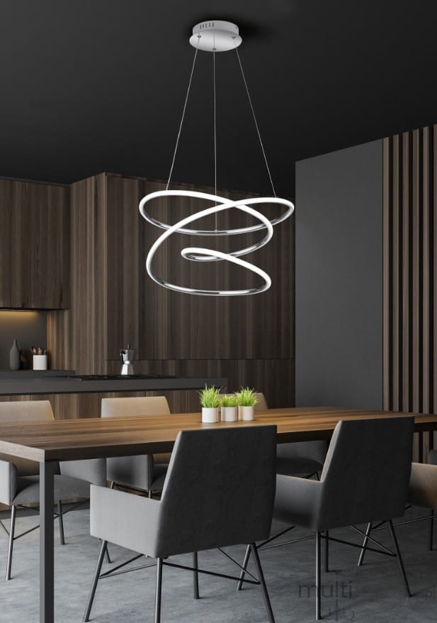 Lampa wisząca Bologna LED 1-punktowa w kolorze chromu, złożona z dwóch spiralnych pierścieni. Zawieszona na cienkich kablach w nowoczesnej aranżacji kuchni, nad drewnianym stołem z szarymi krzesłami i roślinami. Ciemne tło podkreśla elegancję lampy.