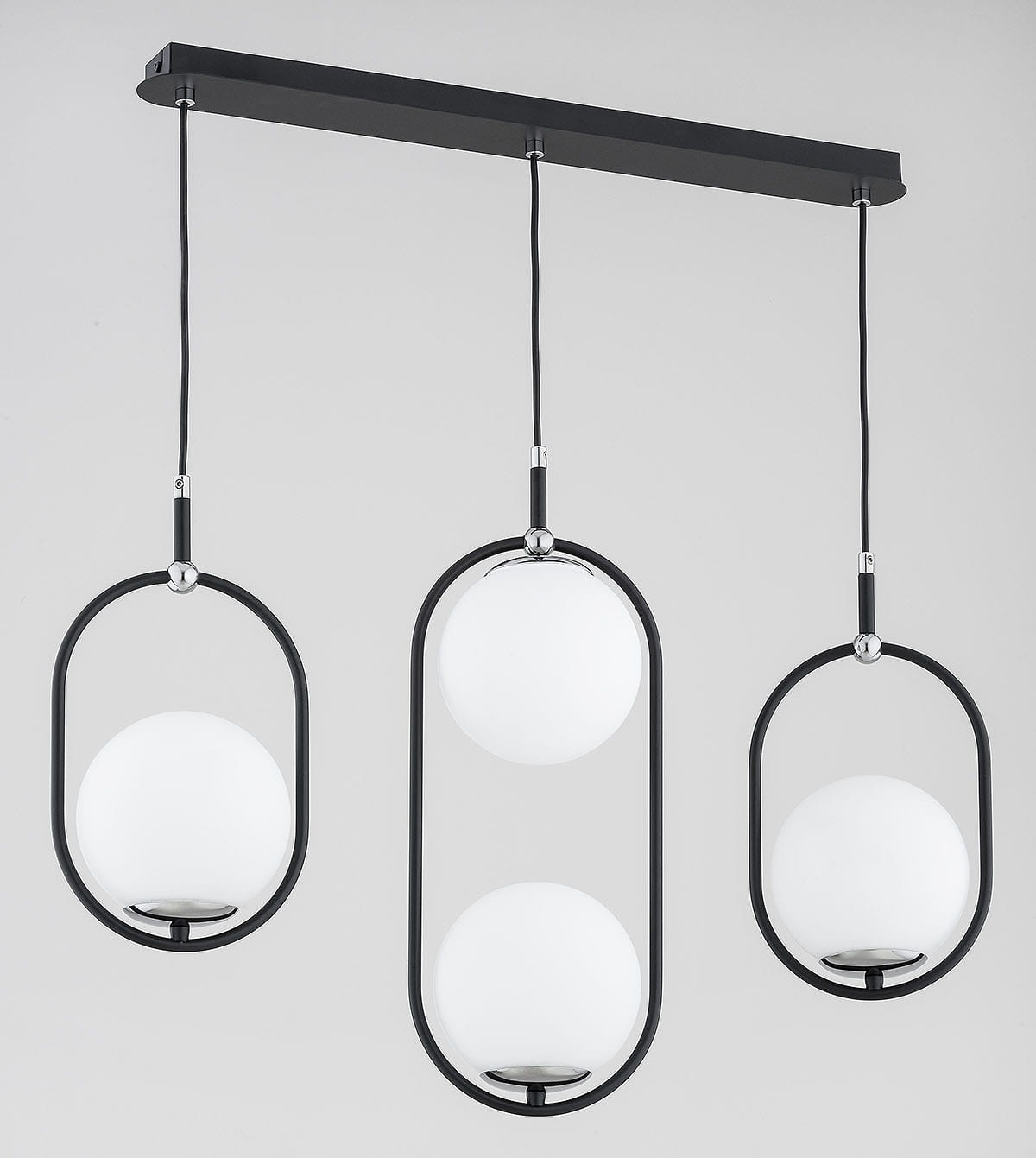Lampa wisząca Amaro 4xE14 w kolorze czarnym i chromowanym. Posiada trzy okrągłe klosze z białego szkła zawieszone na cienkich linkach. Utrzymana w nowoczesnym stylu, zamocowana na prostokątnej podstawie.