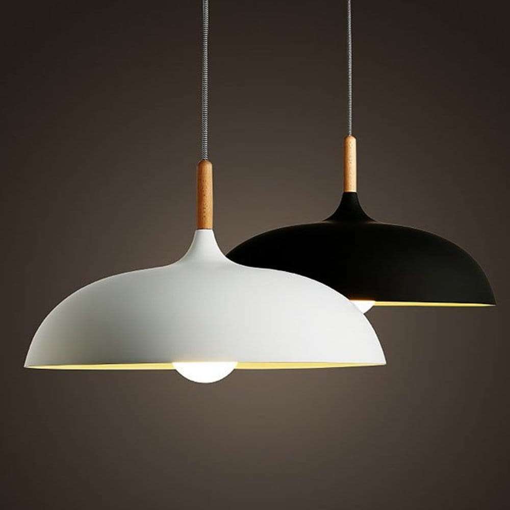 Lampa wisząca Saucer 1xE27 w kolorze czarnym, z okrągłym kloszem i drewnianym uchwytem. Zawieszona na metalowym przewodzie. Widoczna oprawka na żarówkę. Tło w odcieniach ciemnych.
