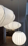 Lampa wisząca Silk D30 w kolorze białym, wykonana z materiału tekstylnego, z okrągłymi kloszami o różnej wielkości. Zawieszona na cienkim przewodzie, z widocznymi dekoracyjnymi liniami. Tło neutralne, z elementami wnętrza w stylu nowoczesnym.
