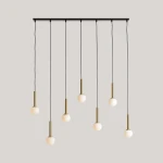 Lampa wisząca Riu 7-punktowa w kolorze czarnym i mosiężnym, z siedmioma okrągłymi kloszami. Klosze zawieszone na czarnych przewodach, zamocowane na prostokątnej podstawie. Elegancki design, idealna do nowoczesnych wnętrz.