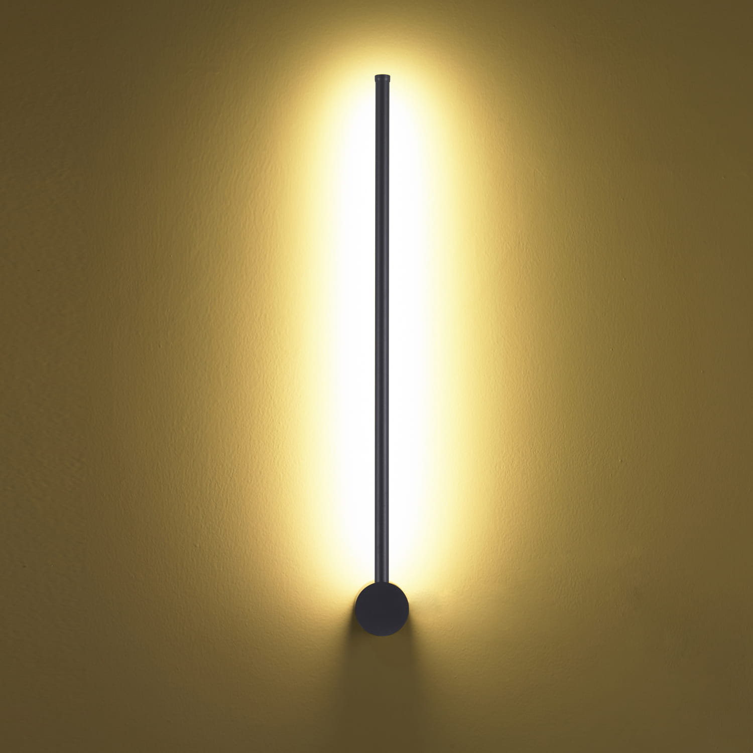 Kinkiet Sparo H60 w kolorze czarnym z jedną diodą LED o mocy 8W. Prosty, pionowy kształt z okrągłą podstawą, emitujący ciepłe światło w górę i w dół, montowany na ścianie, na tle żółtej ściany.