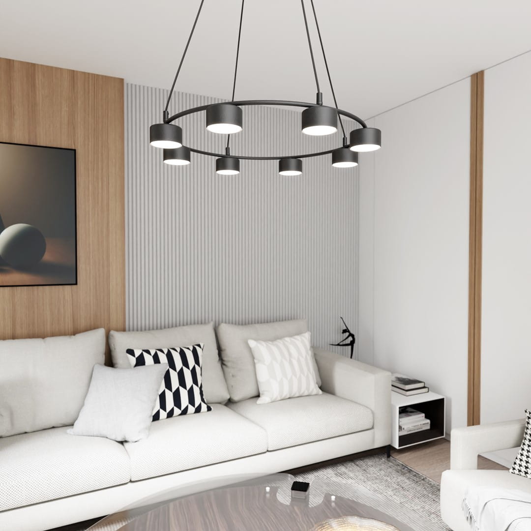 Lampa wisząca Starlit 8xGX53 w kolorze czarnym, z okrągłym metalowym ramieniem, zawieszona na cienkich linkach. Osiem źródeł światła w cylindrycznych kloszach, umieszczonych równomiernie wokół, we wnętrzu z jasnymi sofami i drewnianymi akcentami.
