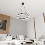 Czarna lampa wisząca Starlit z ośmioma źródłami światła GX53, zawieszona na trzech linkach, w nowoczesnym wnętrzu. Lampa ma okrągły kształt i minimalistyczny design, umieszczona w salonie z jasnymi sofami i drewnianymi akcentami.