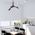 Lampa wisząca Sticks w kolorze czarnym, z sześcioma źródłami światła G9. Zawieszona na cienkim kablu, z minimalistycznym, nowoczesnym designem, składająca się z asymetrycznych ramion. Ujęcie w kuchni, z białymi żaluzjami w tle.