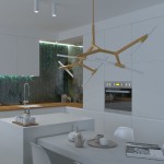 Lampa wisząca Sticks 10xG9 w kolorze złotym, o nowoczesnym, geometrycznym kształcie, z białymi źródłami światła. Zawieszona w kuchni nad białym stołem, w tle zielona ściana z wzorem w jodełkę.