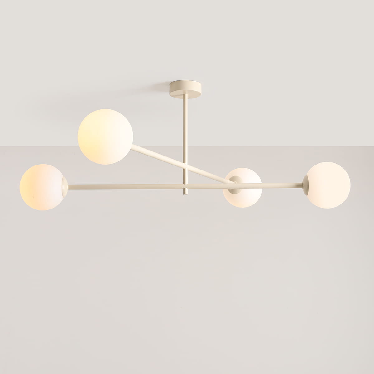 Lampa sufitowa Pinne z czterema oprawami E14 w kremowym kolorze. Konstrukcja z metalowych przęseł z kulistymi kloszami w białym kolorze, zawieszona na suficie, z lekkim, nowoczesnym designem.
