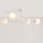 Lampa sufitowa Pinne z czterema oprawami E14 w kremowym kolorze. Konstrukcja z metalowych przęseł z kulistymi kloszami w białym kolorze, zawieszona na suficie, z lekkim, nowoczesnym designem.