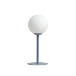 Niebieska lampa stołowa Pinne z jednym gniazdem E14, z okrągłym, matowym kloszem w białym kolorze. Produkt stoi na okrągłej, metalowej podstawie, w prostym, nowoczesnym stylu.