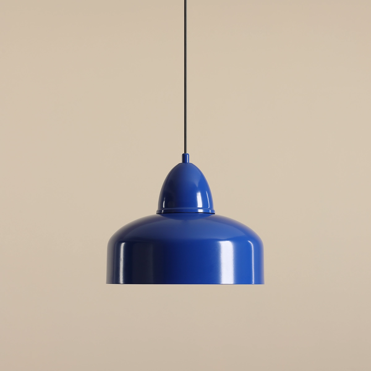 Lampa wisząca Como Cobalt 1-punktowa w intensywnym błękicie, metalowa, o zaokrąglonym kształcie z gładką, błyszczącą powierzchnią. Zawieszona na czarnym przewodzie, z widoczną dekoracyjną górą, na neutralnym, jasnym tle.