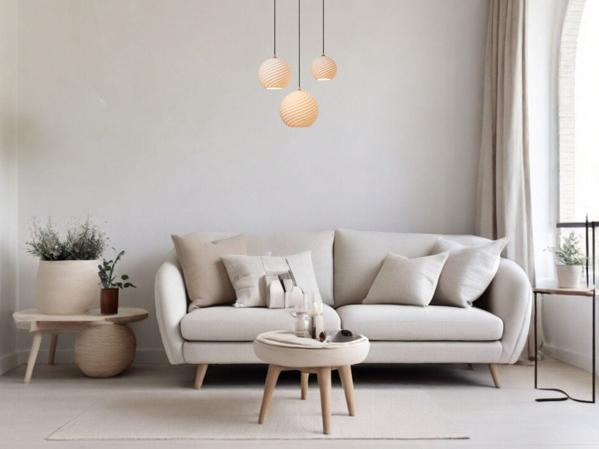Lampa wisząca Bina 3xE27 w kolorze czarnym, zawieszona nad jasną sofą w minimalistycznym wnętrzu. Szklane klosze w kształcie kul z delikatnym wzorem, na tle gładkiej, jasnej ściany. Idealna do nowoczesnych aranżacji.