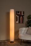 Lampa podłogowa Fold 3xE27 w kolorze czarno-białym, o cylindrycznym kształcie, z białą, teksturowaną obudową. Ustawiona w rogu pokoju obok jasnej sofy, emitująca ciepłe światło. Widoczny czarny stelaż i kabel zasilający. Tło w neutralnym odcieniu.