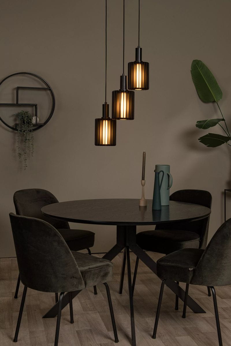 Lambres lampa wisząca 3xE27 w kolorze czarnym, z trzema cylindrycznymi kloszami, zawieszona nad okrągłym stołem. Klosze mają poziome żłobienia, emitując ciepłe światło. W tle widoczna zielona roślina oraz elementy dekoracyjne.