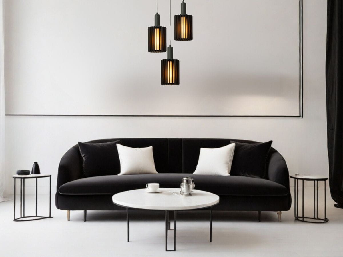 Lambres lampa wisząca 3xE27 w kolorze czarnym, składająca się z trzech cylindrycznych kloszy z pionowymi żłobieniami, zawieszona nad okrągłym stołem w jasnym wnętrzu z czarną sofą i białymi poduszkami.
