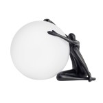 Lampa stołowa Woman-1 z czarną figurką w pozycji siedzącej, obejmującą białą, okrągłą kulę. Kształt lampy podkreśla minimalistyczny design, idealna do modernistycznych wnętrz. Źródło światła E27, stojąca konstrukcja.