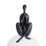 Lampa stołowa Woman-3 z czarną figurą siedzącą, z rękami na twarzy, umieszczona na białym, okrągłym abażurze. Wykonana z matowego materiału, z oprawą na żarówkę E27, prezentująca minimalistyczny design.