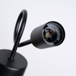 Kinkiet Supeł 1xE27 w kolorze czarnym, ukazujący gniazdo na żarówkę oraz elastyczny uchwyt. Widoczna metalowa podstawa i prosty, nowoczesny design. Zdjęcie zbliżeniowe, eksponujące detal mocowania.