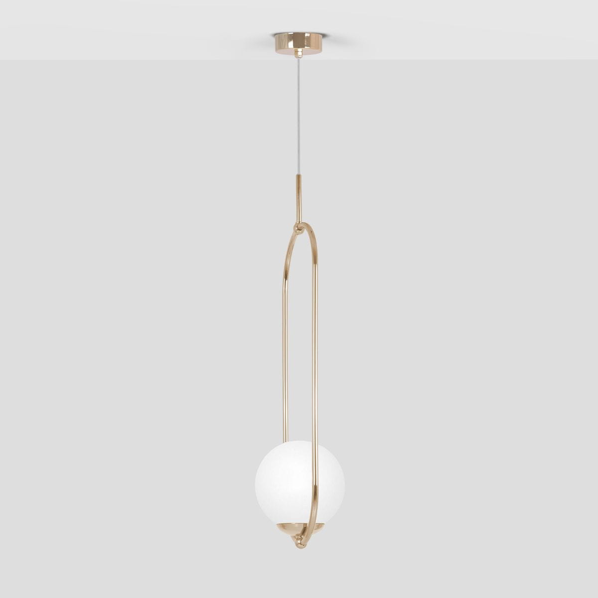 Lampa wisząca Ritus 1xE14 w kolorze złotym i białym, z okrągłym, matowym kloszem zawieszonym w metalowej, złotej ramie. Produkt montowany na suficie, z przezroczystym przewodem. Tło szare, minimalistyczne.