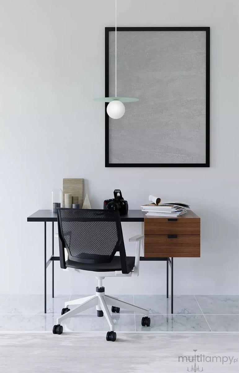 Lampa wisząca Robin D25 w kolorze miętowym i białym z okrągłą źródłem światła, zawieszona nad biurkiem. Widok z boku, w minimalistycznym wnętrzu z czarnym biurkiem i krzesłem. Tło w odcieniach szarości.