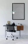 Lampa wisząca Robin D25 w kolorze miętowym i białym z okrągłą źródłem światła, zawieszona nad biurkiem. Widok z boku, w minimalistycznym wnętrzu z czarnym biurkiem i krzesłem. Tło w odcieniach szarości.