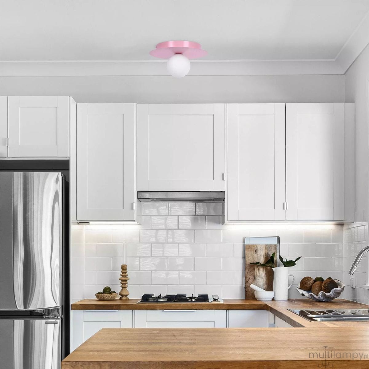 Lampa sufitowa Robin D25 z różowym okrągłym kloszem i białą kulistą żarówką, zamontowana na suficie kuchni. Produkt w nowoczesnym stylu, o prostym kształcie, w otoczeniu białych mebli i drewnianego blatu.