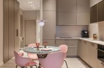 Lampa wisząca Robin D25 z różowym kloszem i białą kulą, zawieszona nad okrągłym stołem. W tle nowoczesna kuchnia z szarymi meblami i różowymi krzesłami. Kąt ujęcia frontalny, produkt dobrze widoczny w kontekście aranżacji.