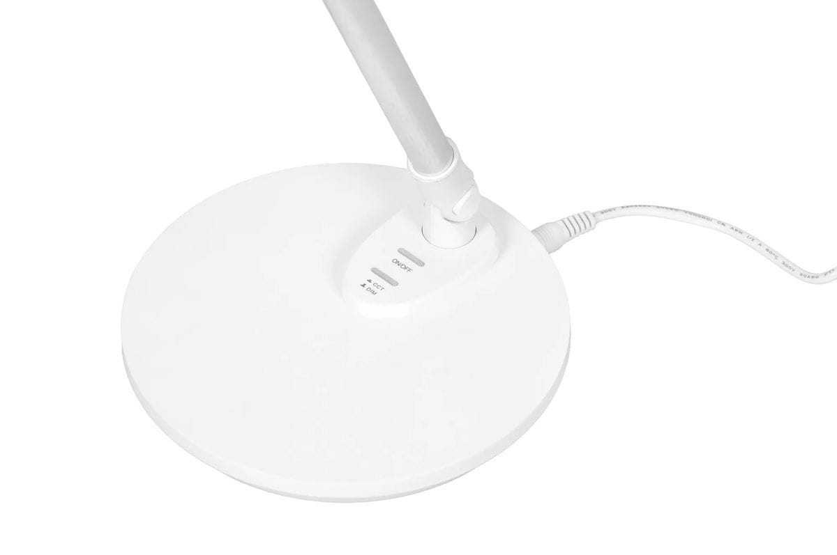 Biała lampka biurkowa Bolek K-BL1527 z jednym źródłem LED 7W, z regulacją barwy światła 3000-6000K. Ujęcie z boku, widoczna okrągła podstawa oraz przyciski do włączania i zmiany ustawień. Kabel zasilający w kolorze białym.