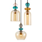 Lampa wisząca Busco z trzema kloszami, w kolorze czarnym i bursztynowym. Klosze w różnych kształtach: cylindryczny, stożkowy i kulisty, ozdobione kolorowymi elementami szklanymi. Zawieszona na czarnym przewodzie, w nowoczesnym stylu.