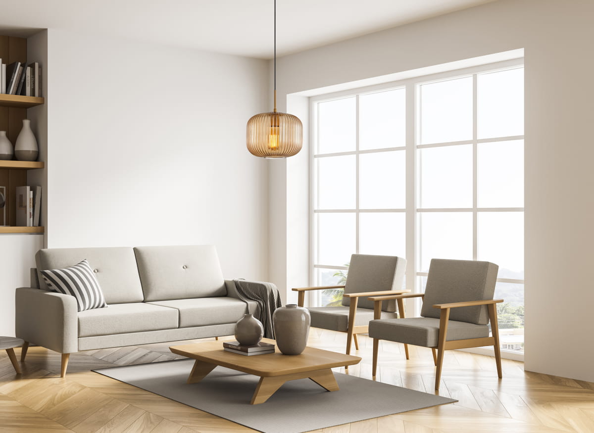 Lampa wisząca Gavino 1xE27 w kolorze czarnym z bursztynowym kloszem, o zaokrąglonym kształcie, zawieszona na cienkim metalowym przewodzie. Umieszczona w jasnym wnętrzu z szarym sofą i drewnianymi meblami, tworzy nowoczesny akcent.