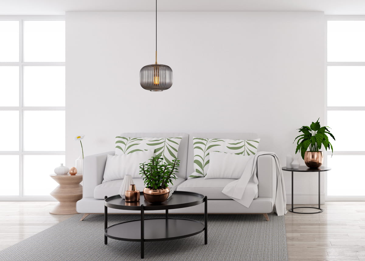 Lampa wisząca Gavino 1xE27 w kolorze czarnym z dymionym kloszem, zawieszona nad białą kanapą. Oświetlenie w stylu nowoczesnym, idealne do aranżacji wnętrz. Klosz ma delikatne żłobienia, a złote detale dodają elegancji.