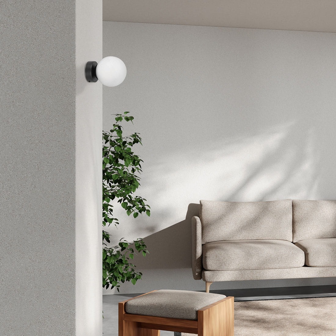 Lampa sufitowa Inez 1xE14 w kolorze czarnym i białym, zamontowana na ścianie. Okrągła, biała kula świetlna kontrastuje z czarnym uchwytem. W tle widać roślinę oraz sofę w jasnym kolorze na tle szarej ściany.