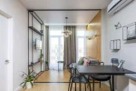 Lampa wisząca Piro w kolorze czarnym z bursztynowymi kloszami, z pięcioma gniazdami E14. Zawieszona w centralnej części pomieszczenia, w nowoczesnym wnętrzu z drewnianymi akcentami i jasnym tłem.