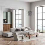 Lampa wisząca Amiria w kolorze czarnym, z oprawą E27, zawieszona w nowoczesnym wnętrzu. Okrągła, siatkowa konstrukcja z widocznym żarnikiem. Otoczenie: jasny salon z dużymi oknami, drewnianą podłogą i minimalistycznymi meblami.